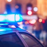 Chilling Find Near Gym — ID Of Dead Body Still Pending Close-up of a police car with blue emergency lights in a city at night