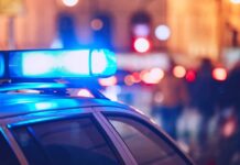 Chilling Find Near Gym — ID Of Dead Body Still Pending Close-up of a police car with blue emergency lights in a city at night