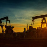 FBI-Style Oil Crackdown Looms Graphical representation of oil prices with oil pumps at sunset