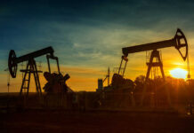 FBI-Style Oil Crackdown Looms Graphical representation of oil prices with oil pumps at sunset