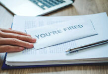Meta’s AI Hit New Moms? A hand resting on an envelope labeled 'YOU'RE FIRED' on a desk with papers and a pen