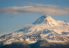 Clouds Block Helo — Rescuers Gamble Big Snow-covered mountain peak partially obscured by clouds
