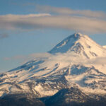 Clouds Block Helo — Rescuers Gamble Big Snow-covered mountain peak partially obscured by clouds