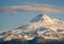 Clouds Block Helo — Rescuers Gamble Big Snow-covered mountain peak partially obscured by clouds