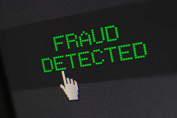 shutterstock_1806836992 Fraud detected text with a pixelated cursor icon.