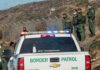 ICE Blitz Shocks June — What Changed? Border Patrol agents and vehicles at fenced border area.
