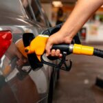 Price Shock Slams Pumps A person refueling a car at a gas station