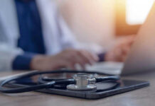 Hero Pilot’s Diagnosis Sparks Outpouring Of Support Stethoscope and tablet on desk, doctor using laptop.