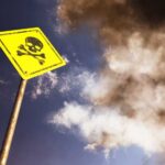 Rooftop Bacteria Kills Five — Who’s Liable? Yellow skull and crossbones warning sign against smoky sky
