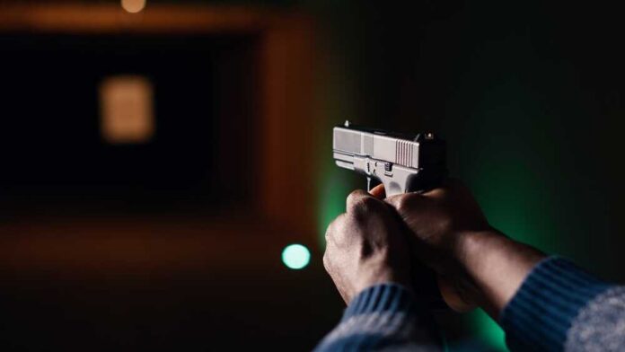 Man,Holding,Pistol,Enjoying,Recreational,Indoor,Shooting,Experience,In,Firing