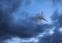 Airline Cabin Odor Forces Atlantic Detour An airplane flying through a cloudy sky