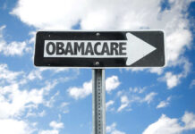 Obamacare Exodus Stuns Washington Directional sign pointing towards Obamacare against a blue sky