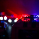 Manhunt For Cop Killer Ends In Woods Police car lights shining in the dark.