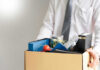 Person holding a box of personal office items.