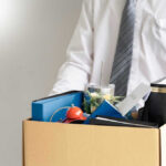 Person holding a box of personal office items.