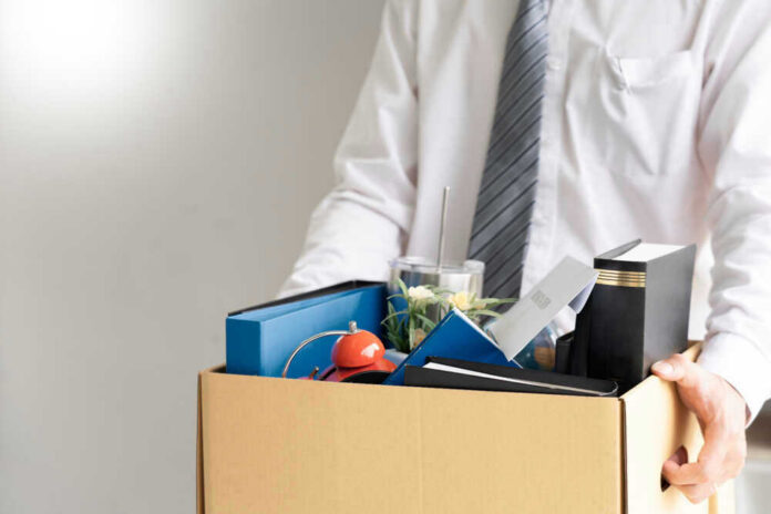 Person holding a box of personal office items.