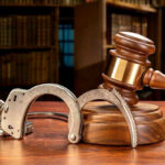 WWII Memorial Vandalized — Feds Capture Suspect Wooden gavel and handcuffs on a table.