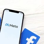 Meta’s $18B Surrender: What’s Hidden? Phone displaying Facebook app in a car