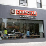 Chipotle Mexican Grill restaurant exterior with people inside.