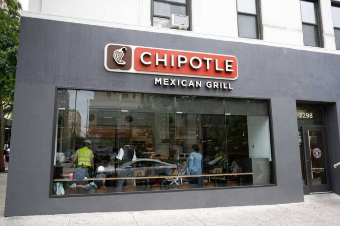 shutterstock_2177661559 Chipotle Mexican Grill restaurant exterior with people inside.