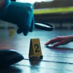 Sunday Gathering Becomes Mass Murder Scene A detective examining evidence at a crime scene with markers on the floor