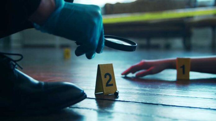 Detective,Collecting,Evidence,In,A,Crime,Scene.,Forensic,Specialists,Making A detective examining evidence at a crime scene with markers on the floor