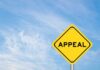 A yellow diamond-shaped sign with the word 'APPEAL' against a blue sky