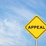 Appeals Showdown: Law And Order Vs Activism A yellow diamond-shaped sign with the word 'APPEAL' against a blue sky