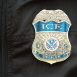 ICE Blitz Surges — See What’s Driving It Close-up of an ICE officer badge on a black jacket