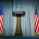Press Room Shock: Sudden Exit Raises Stakes Press podium with the White House sign and an American flag in the background