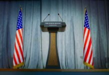 Press Room Shock: Sudden Exit Raises Stakes Press podium with the White House sign and an American flag in the background