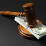Judges Warn: No Payback With Federal Cash Judge’s gavel resting on a stack of US hundred-dollar bills