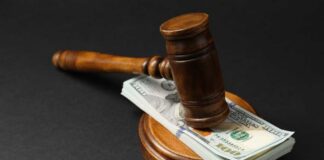 Judge’s gavel resting on a stack of US hundred-dollar bills