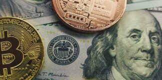 Close-up of a Bitcoin and other coins on a US dollar bill