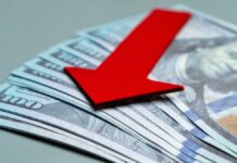 Red downward arrow on U.S. dollar bills