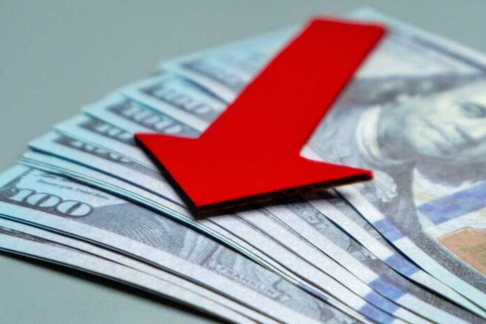 Red downward arrow on U.S. dollar bills