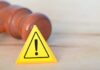 Yellow warning triangle with exclamation mark beside a wooden gavel