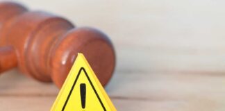 Yellow warning triangle with exclamation mark beside a wooden gavel