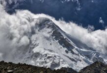 Glacier Spits Out Long-Lost Climbers Snow-covered mountain peak partially obscured by clouds