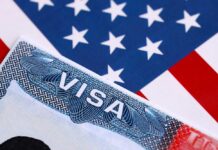 Close-up of a US visa on a background of the American flag