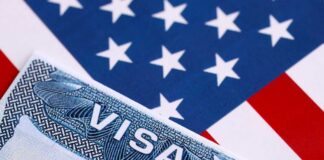 Close-up of a US visa on a background of the American flag