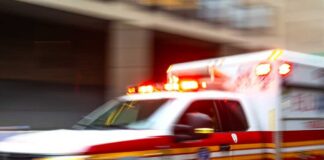 Ambulance with flashing lights speeding through a city street