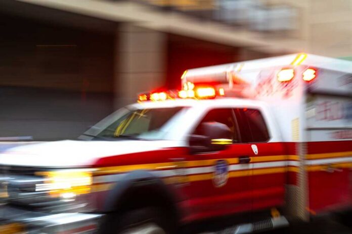 Ambulance with flashing lights speeding through a city street