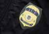 ICE Shooting Clash: Constitution In Crosshairs Close-up of an ICE officer badge on a black jacket