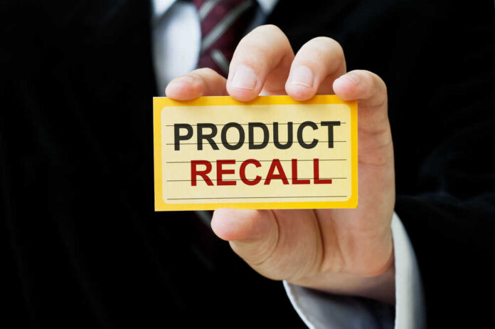 Hand holding a product recall card