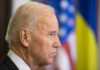 Biden Pardon Twist Jolts Fauci Fight Joe Biden, side profile, flags behind.