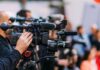 Frail McConnell Reappears, Then Stuns The Floor Video cameras on tripods at a media event