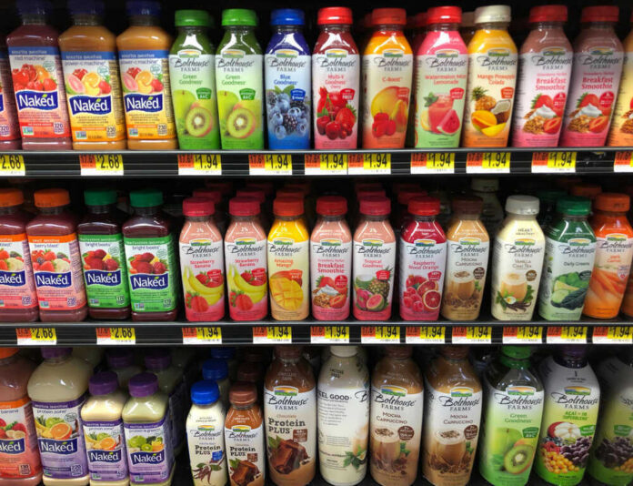 Bottled drinks on store shelves, including Naked and Bolthouse brands.