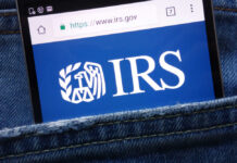 GOP Hurls IRS Grenade at Longtime Charity Smartphone showing IRS website in a denim pocket