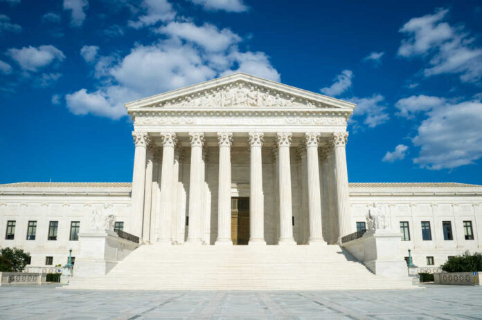 Supreme,Court,Of,The,United,States,Building,Front,Entrance,With Supreme Court building with grand columns and steps under a blue sky